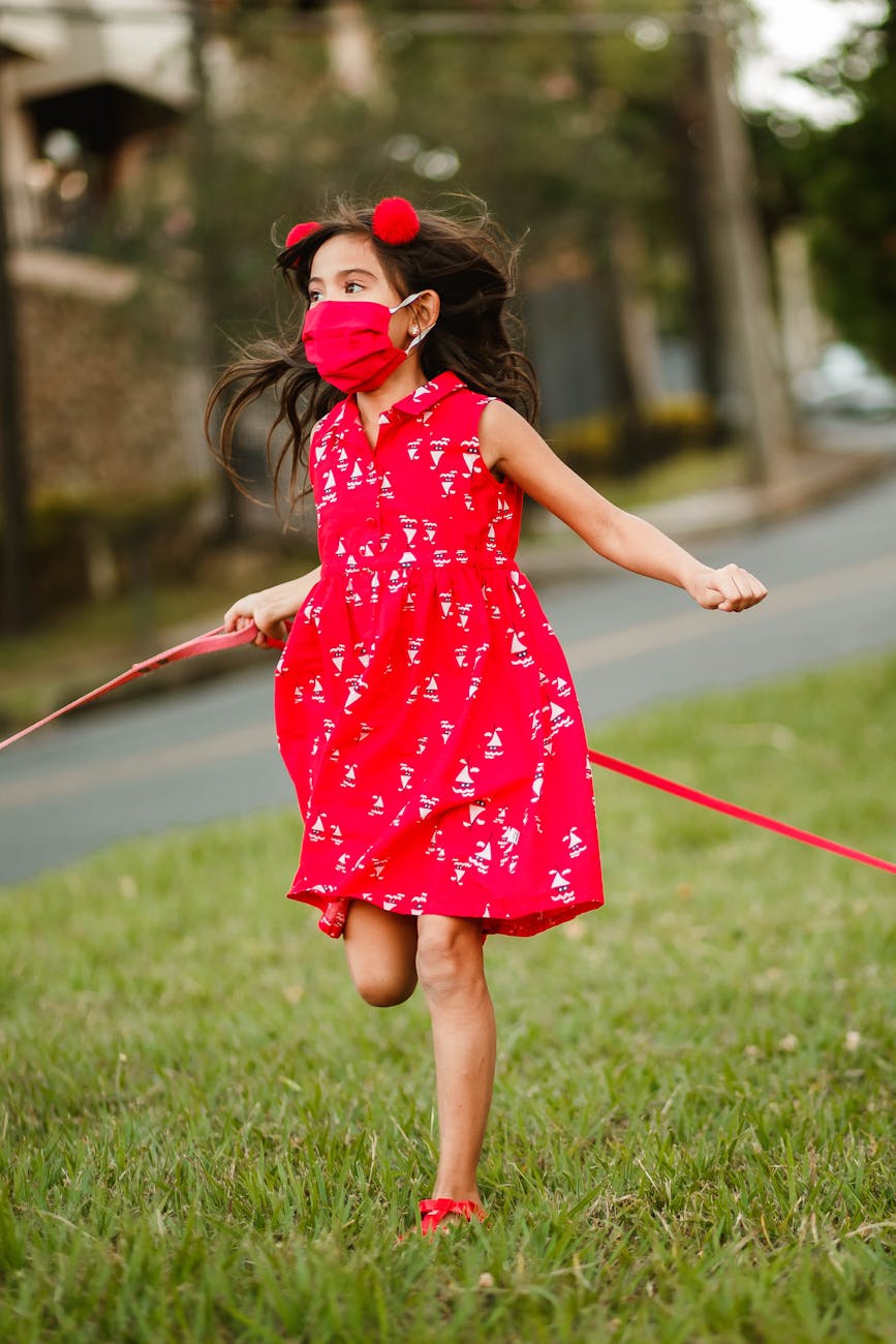 playful girl in mask running along lawn